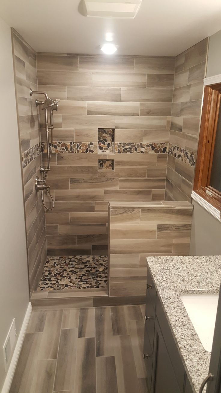 a walk in shower sitting inside of a bathroom next to a sink and counter top