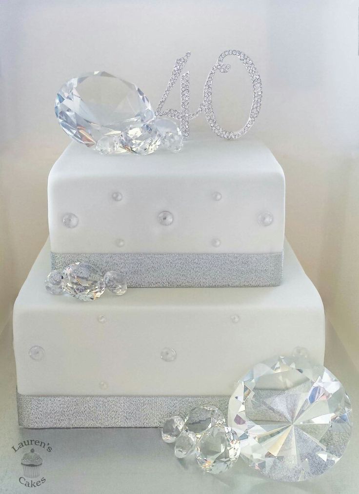 a three tiered white cake with diamonds on top and the number 40 on it