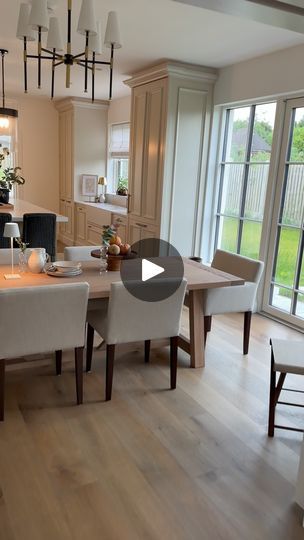 a dining room table and chairs in front of an open kitchen with sliding glass doors