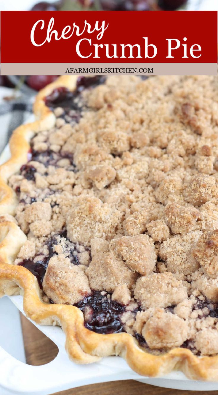 cherry crumb pie on a white plate with cherries in the background and text overlay reading cherry crumb pie