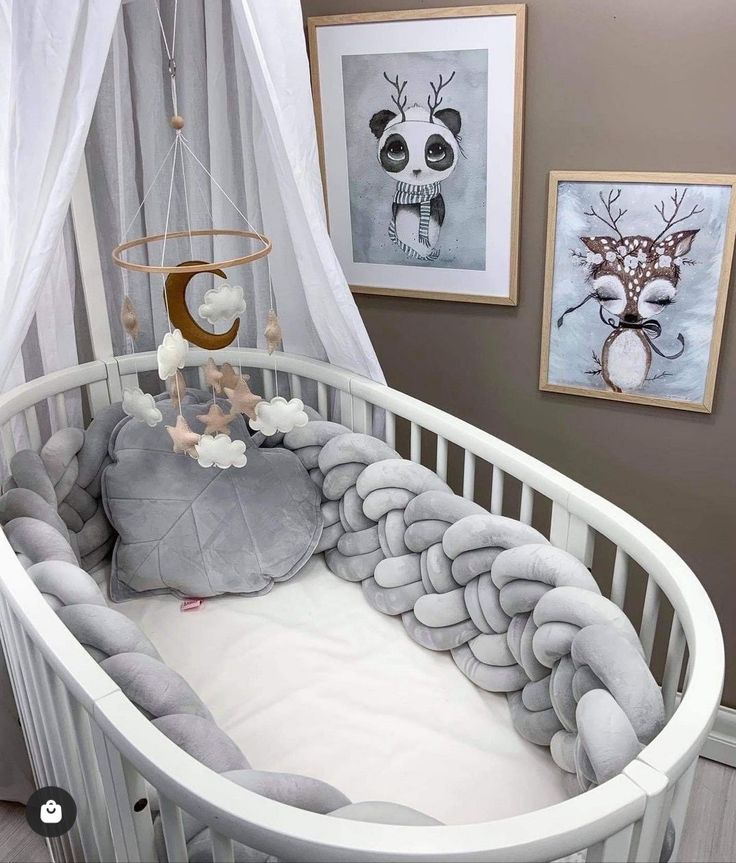 a baby crib in a room with pictures on the wall