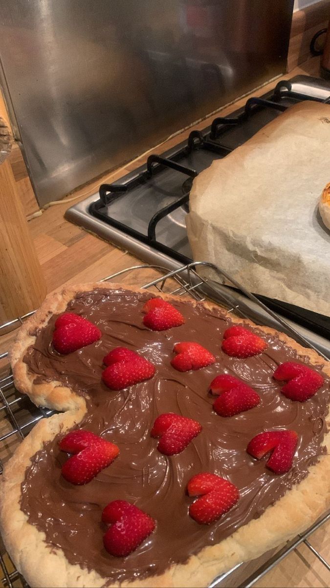 two uncooked pies sitting on top of metal racks in front of an oven