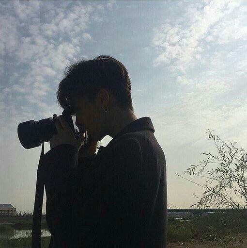 a person taking a photo with a camera on a sunny day in the country side