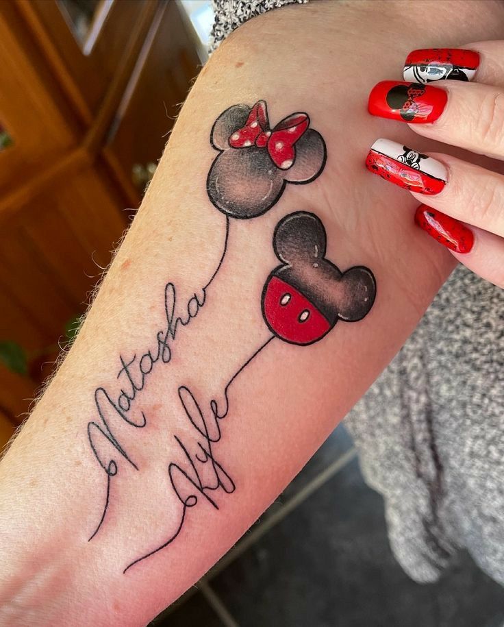 a woman's arm with a minnie mouse tattoo on it and the words mama mia written in black ink