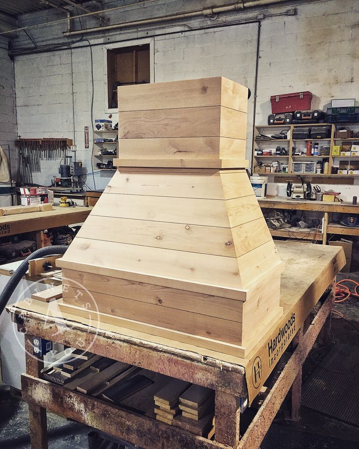 a wooden stove top sitting on top of a workbench