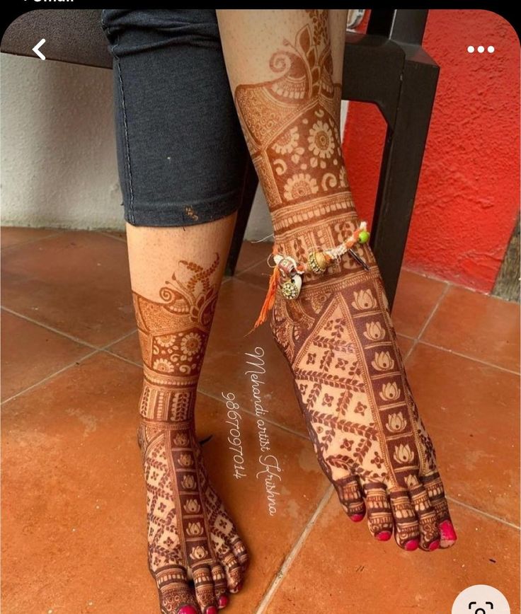 a woman's feet with henna tattoos on them