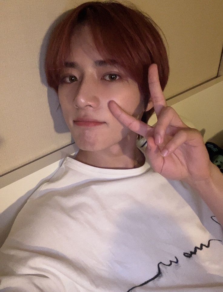 a man with red hair making a peace sign