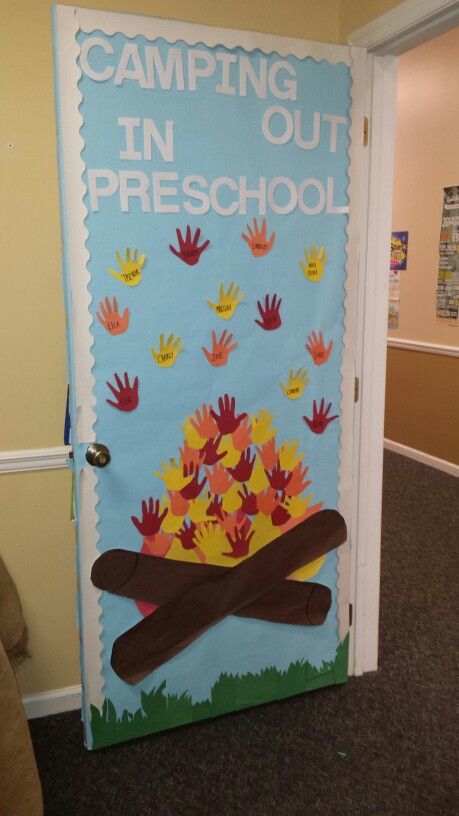 a door decorated with handprints and writing that says camping out in pre school