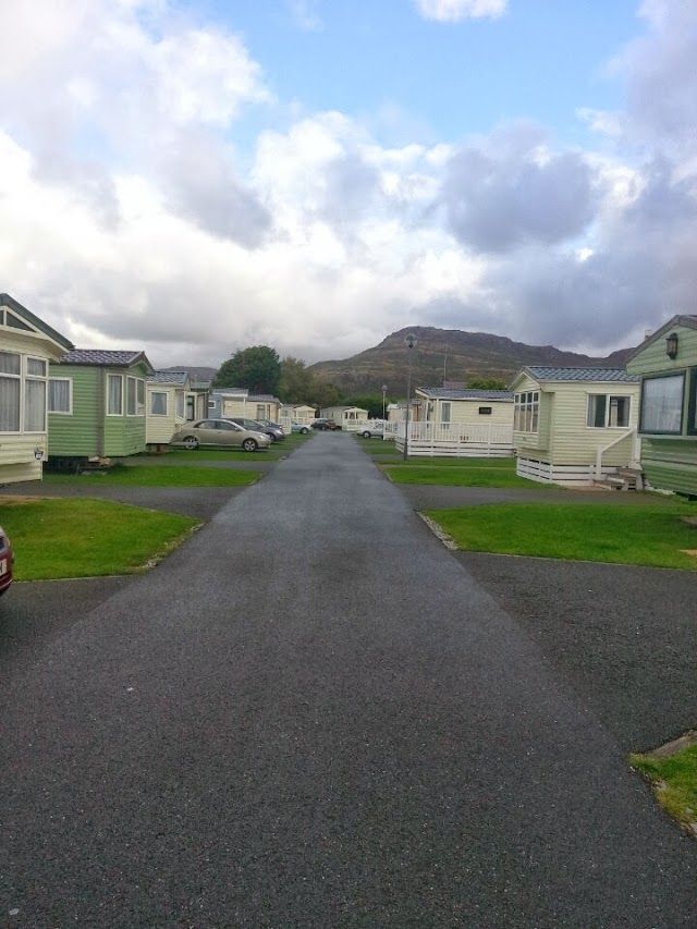 a car parked on the side of a road in front of several mobile home units