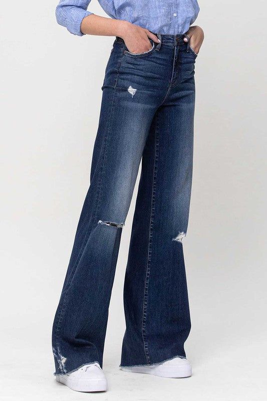 Elevate your denim game with these Flying Monkey High Rise Distressed Wide Leg Jeans. These jeans boast a high-rise waist for a flattering silhouette, while the wide leg design adds a touch of retro elegance. The distressed detailing infuses an edgy element, making these jeans a versatile choice to effortlessly combine modern trends with a hint of vintage-inspired style.F. Rise: 10"Inseam: 34'' Leg Opening: 22''Model is 5' 8'' Wearing size26Fabric Contents: 93% Cotton, 5% Polyester, 2% Spandex, Distressed High Waist Flare Jeans Medium Wash, Distressed High-waist Medium Wash Flare Jeans, High Waist Distressed Medium Wash Flare Jeans, High-waist Distressed Medium Wash Flare Jeans, Fall Ripped High-rise Flare Jeans, Fall High Rise Ripped Flare Jeans, Wide Leg Jeans With Frayed Hem For Fall, Fall Wide Leg Jeans With Frayed Hem, Ripped High Rise Flare Jeans In Dark Wash