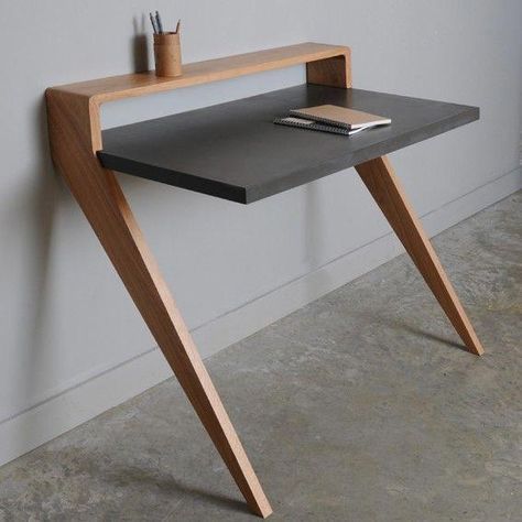 a wooden table with a book on it next to a white wall and a window