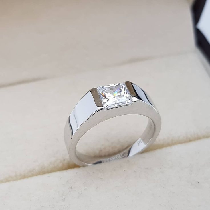 a white gold ring with a princess cut diamond