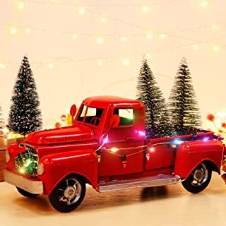 an old red truck with christmas trees in the back