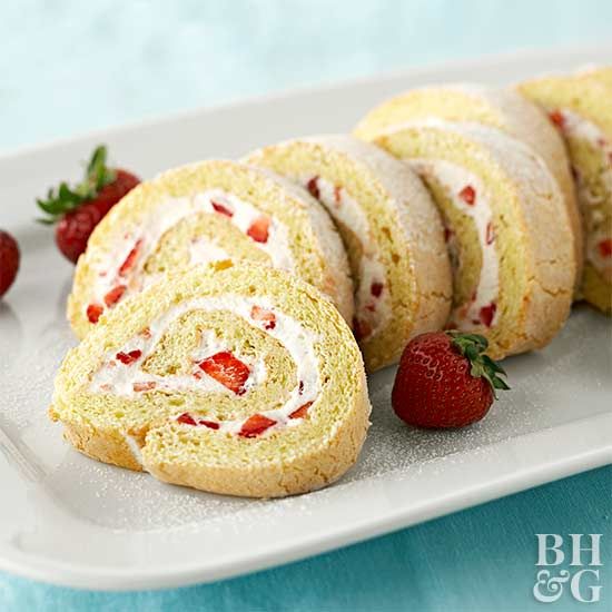 strawberry cream roll on a white plate with strawberries