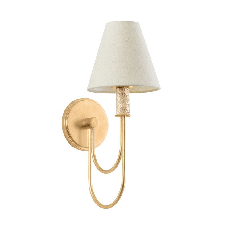 a gold wall light with a white shade on the side and a beige fabric shade on the arm