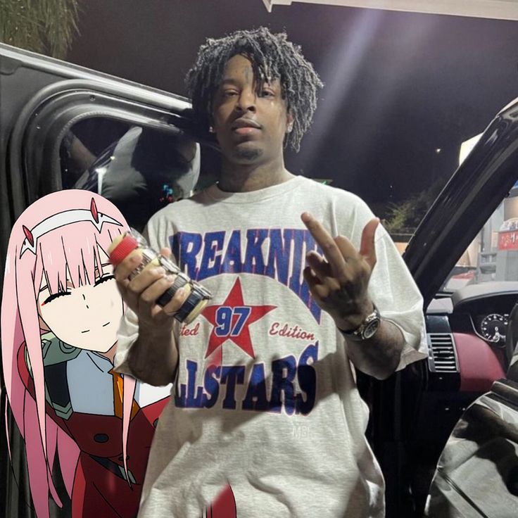 a man with dreadlocks standing in front of a car