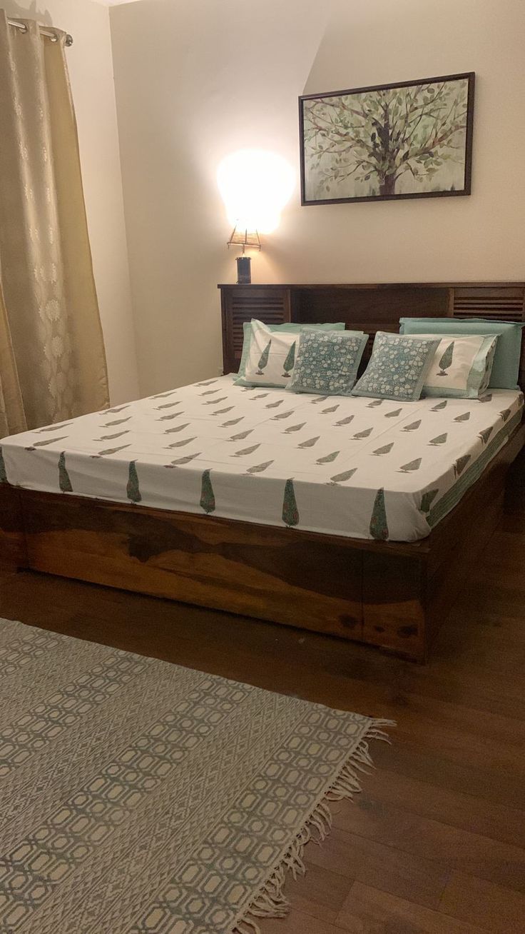 a bed sitting on top of a hard wood floor next to a wooden headboard