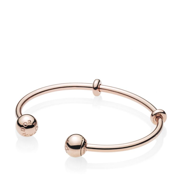 A sleek addition to your jewelry box, Pandora's 14K rose gold-plated Pandora Moments Open Bangle is minimally detailed with silicone stoppers that double as adornments. The polished style is plated with 14K rose gold for a warm finish. The logo-embossed end caps are easily removed to add charms — and are interchangeable to suit your mood. Classic Adjustable Rose Gold Bangle, Adjustable Modern Rose Gold Bangle, Modern Adjustable Rose Gold Bracelets, Pandora Logo, Pandora Rose Gold, Open Bangle Bracelet, Pandora Rose, Polished Style, Bracelet Pandora