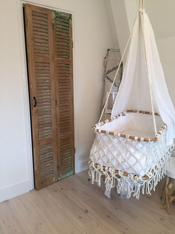 a hammock hanging from the ceiling in a room with wooden floors and white walls