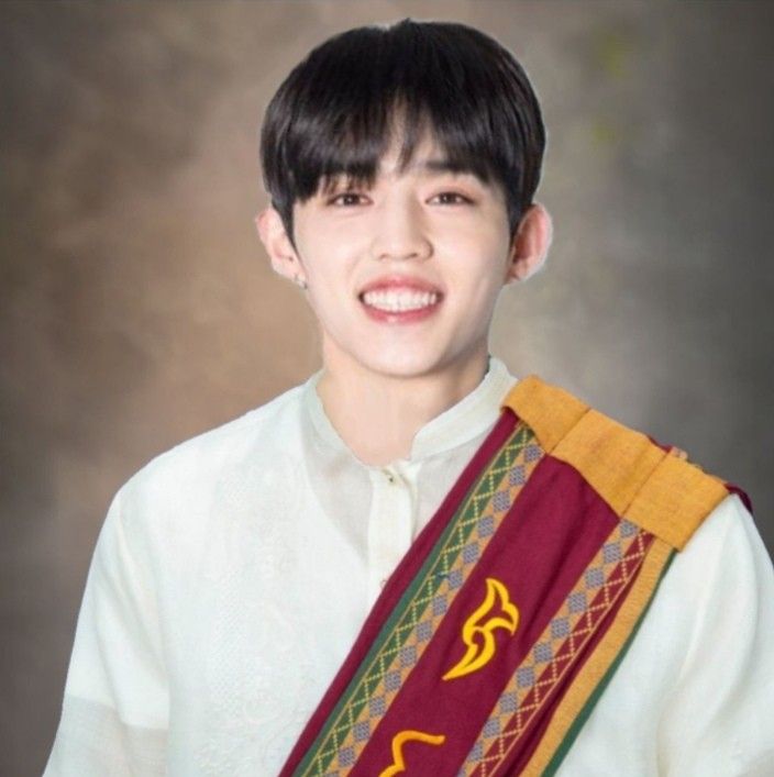 a young man wearing a white shirt and holding a red and yellow scarf over his shoulder