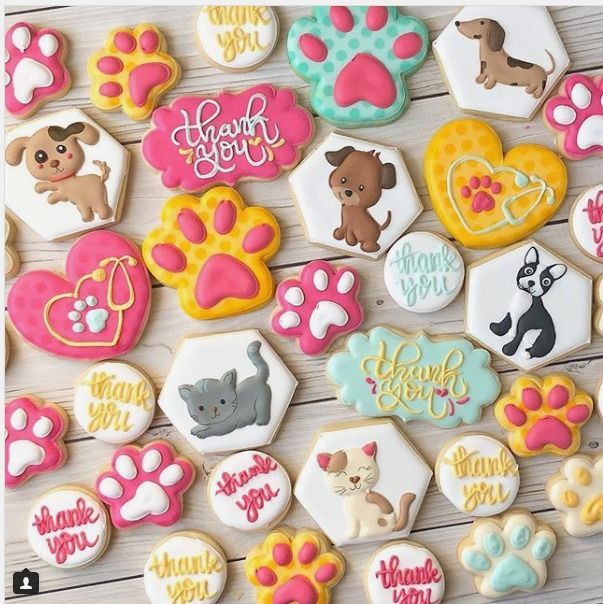 decorated cookies with dog paw prints and name on them are displayed in front of a wooden background