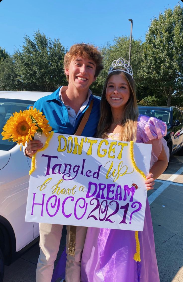 a man and woman holding a sign that says, don't get tangled to have a dream hocco?