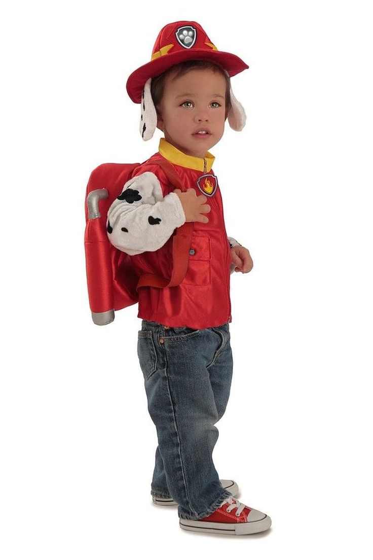 a little boy in a fireman costume holding a stuffed animal