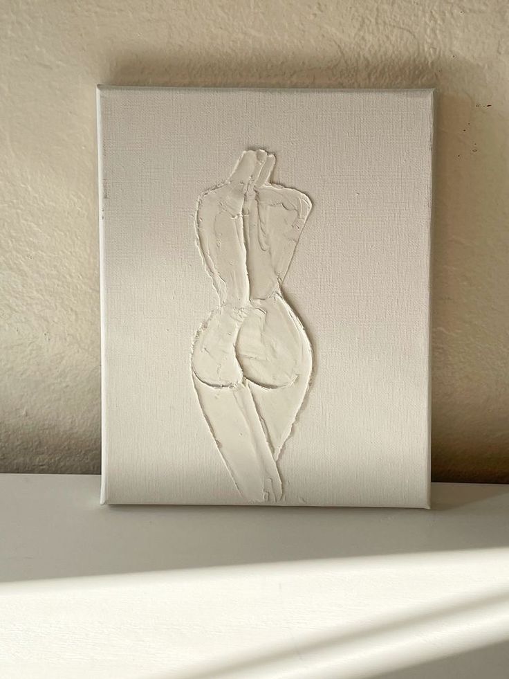 a white painting with a woman's torso on it