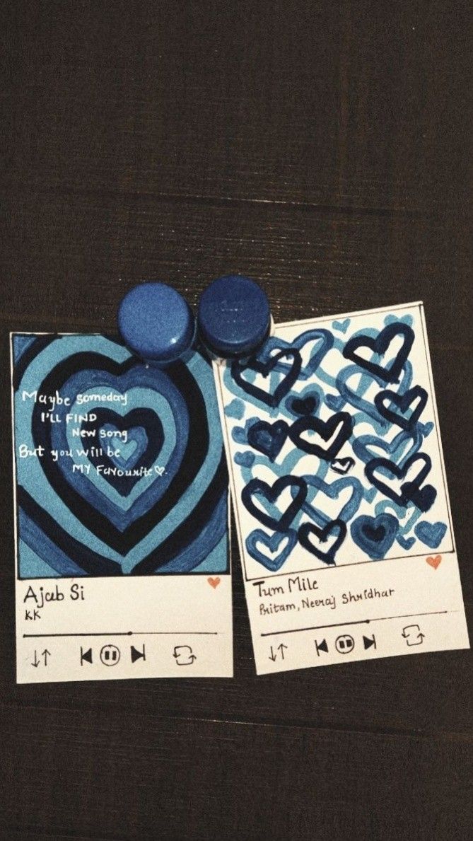 two cards with blue designs on them sitting next to each other, one has a heart in the middle