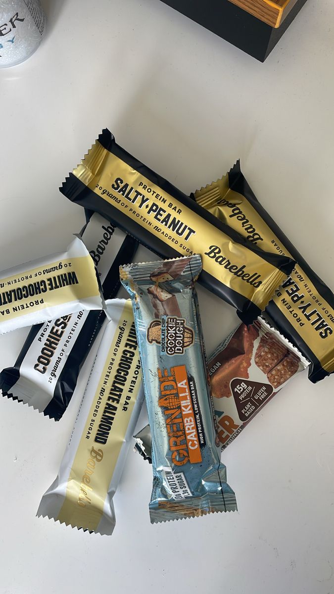 several different types of candy bars sitting next to each other on a white counter top