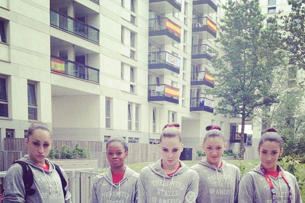 a group of young women standing next to each other in front of a tall building