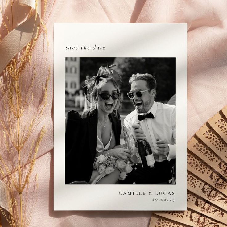 a wedding card with an image of a man and woman holding champagne flutes on top of a table