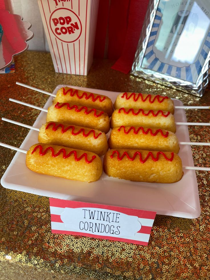 there are five hotdogs on a plate with toothpicks in front of them