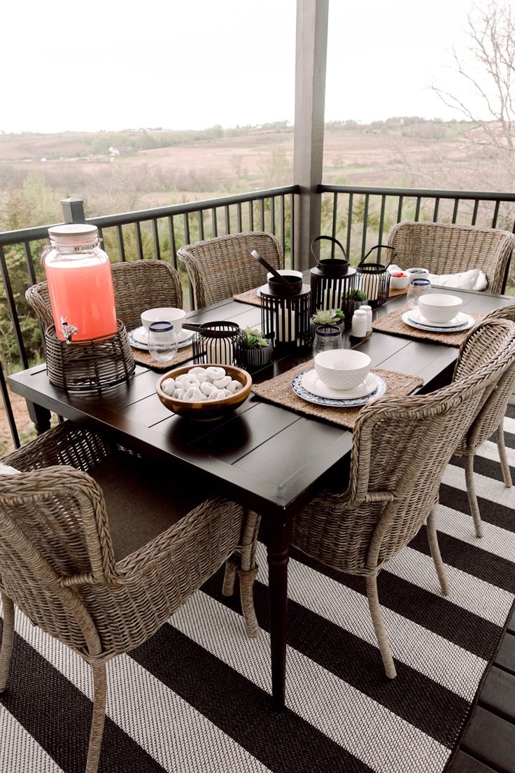 the table is set on the porch with plates and utensils