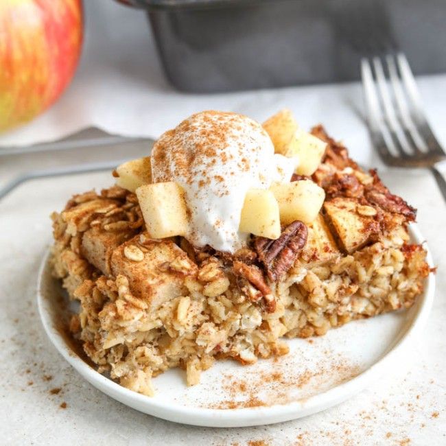 a white plate topped with granola covered in ice cream next to an apple pie