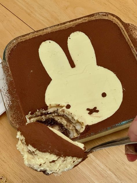 someone is cutting into a cake with chocolate frosting and a bunny face on it