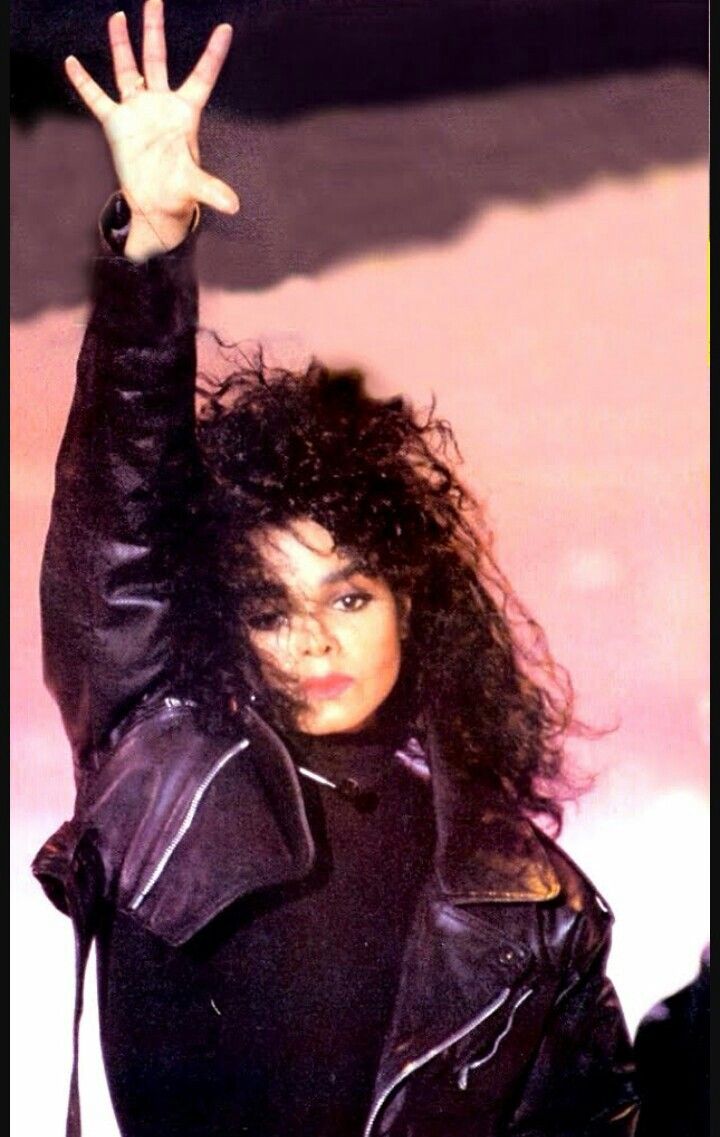 an image of a woman with long hair wearing a leather jacket and posing for the camera