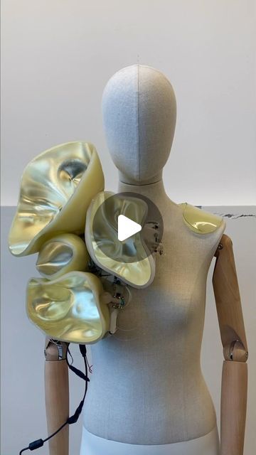 a mannequin with multiple pieces of art on it's head and torso