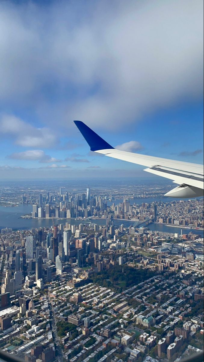 an airplane wing flying over a large city