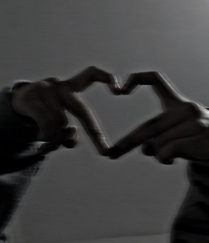 two people making a heart shape with their hands