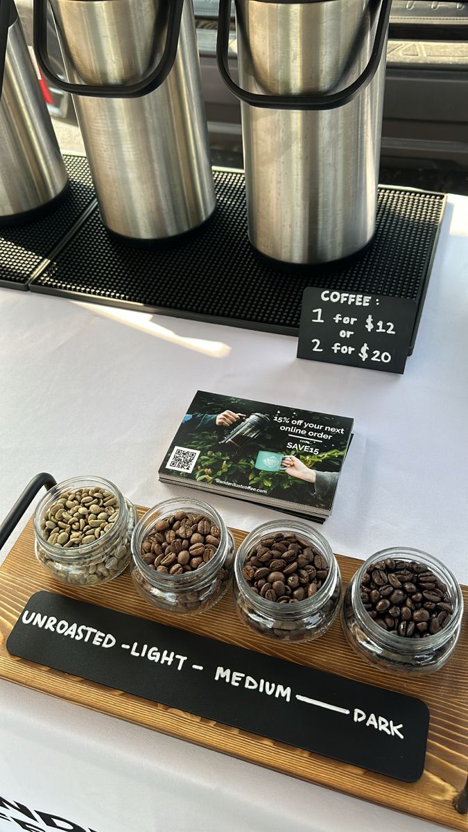 there are four cups on the table with coffee beans in them and two mugs next to it