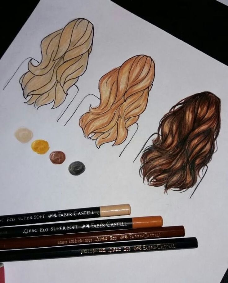 some pencils are laying on top of a piece of paper that has drawings of women's hair