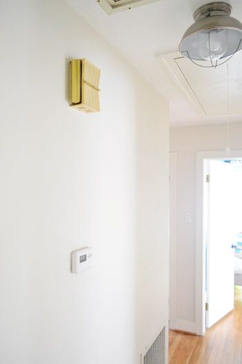 an air conditioner mounted to the side of a white wall next to a door