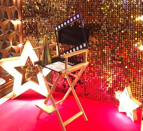 a red carpeted room with gold sequins and stars on the wall behind it