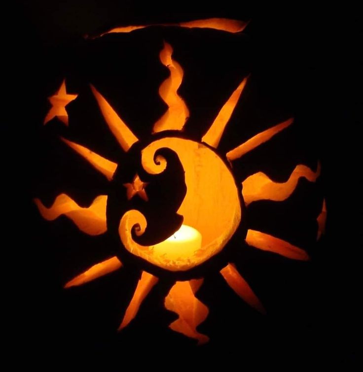 a pumpkin carved to look like a sun and moon with the letter c on it