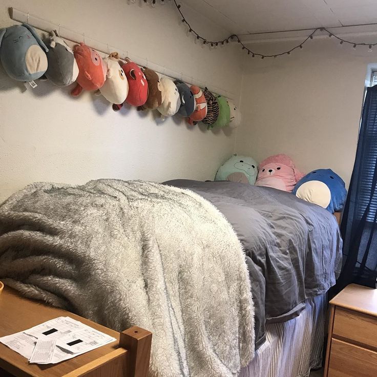 a bed with several stuffed animals hanging on the wall