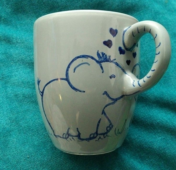 a coffee cup with an elephant painted on the side and hearts drawn on the inside