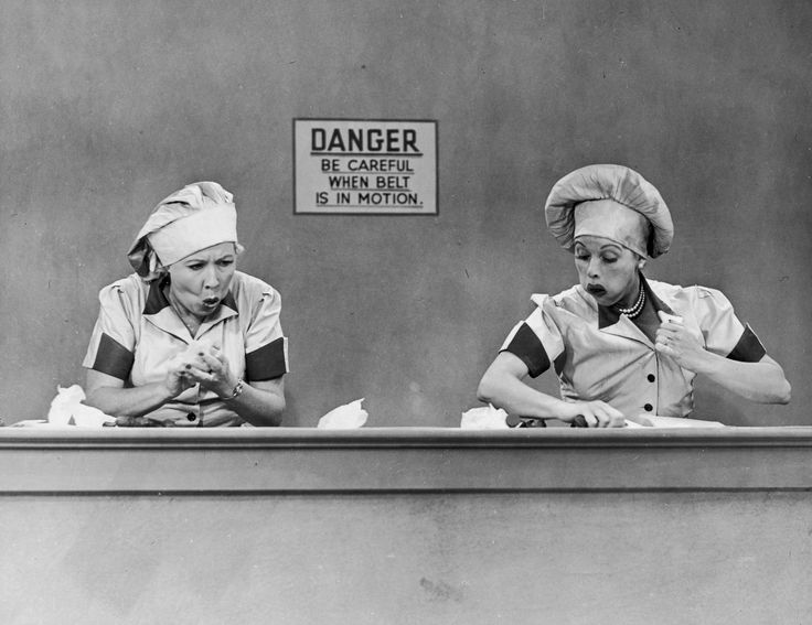 two women in chef hats are looking at knives