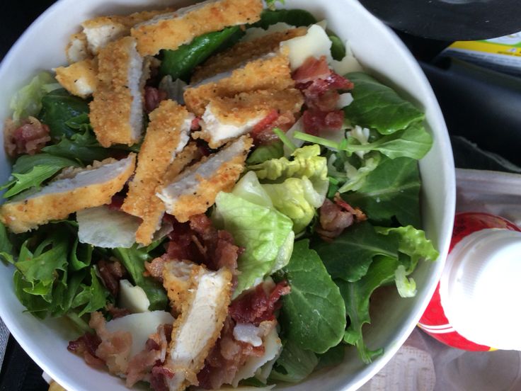 a white bowl filled with lettuce and meat