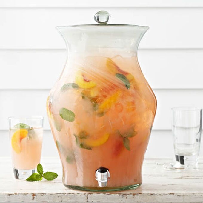 a pitcher filled with liquid next to two glasses